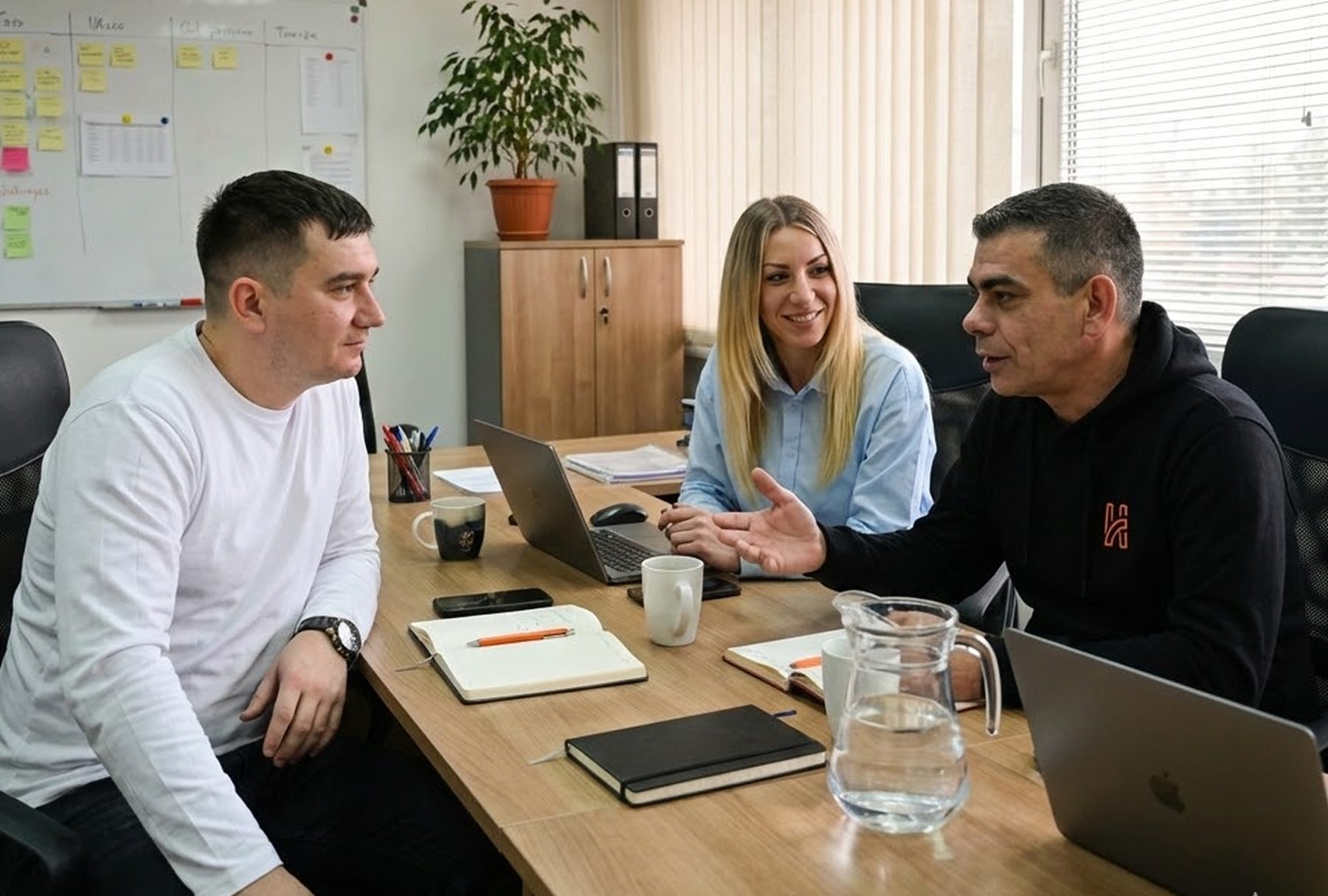Troje članova tima Humble Logisticsa u razgovoru za stolom u uredu